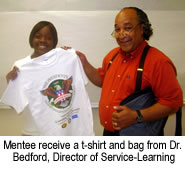 Mentee receives a T-shirt and bag from Dr. Bedford, Director of Service Learning.